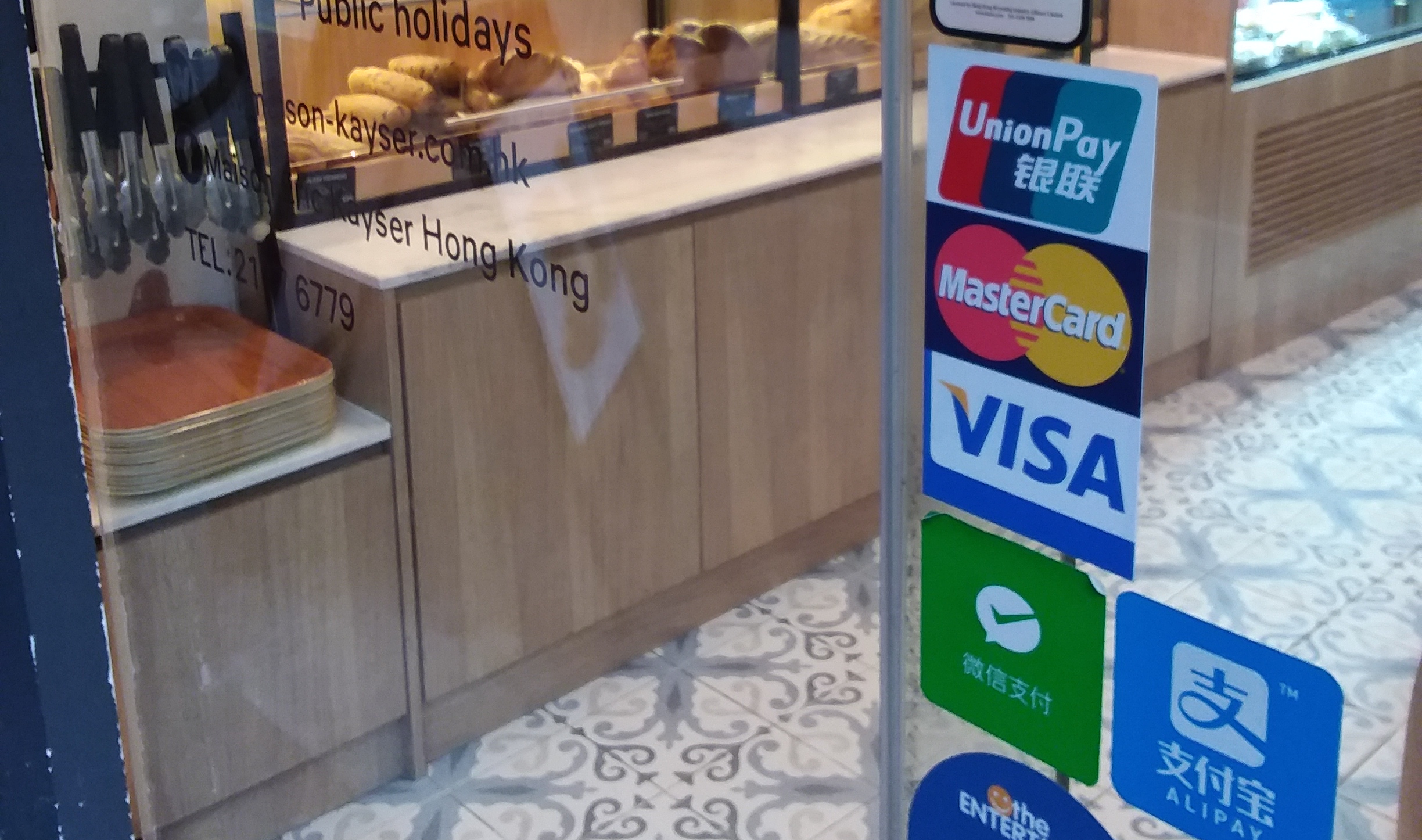 Storefront, glass door, with a bunch of stickers from card networks indicating that the store accepts many different payment methods